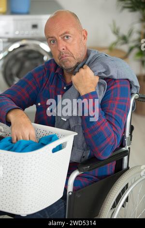 disabled man doing laundry Stock Photo