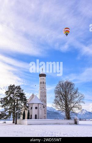 Hot air balloon over the Sankt Coloman pilgrimage church near Schwangau in winter, Allgäu, Swabia, Bavaria, Germany, Europe Stock Photo