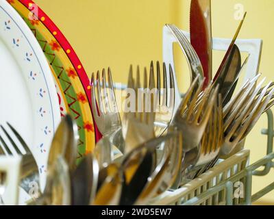 A Dishwasher loaded with cutlery and plates ready to be washed. Stock Photo