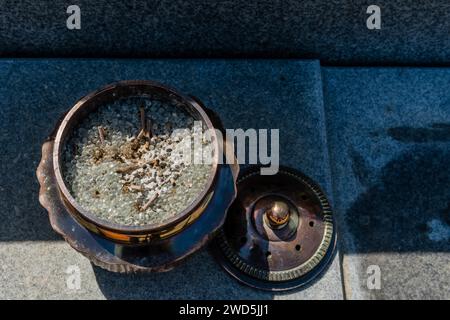 Top view of opened bronze incense bowl filled with small round glass beads on concrete slab, South Korea, South Korea Stock Photo