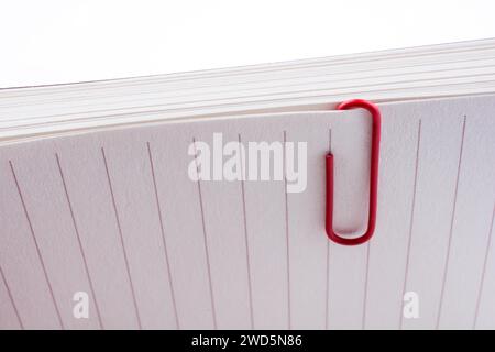 Colored paper clip on a checked notebook page Stock Photo