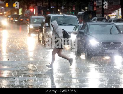 People try to protect themselves from the rain on Potsdamer Strasse. After weeks of heat, the first heavy rain brought cooling, Berlin, 15.08.2022 Stock Photo