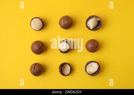 Tasty Macadamia nuts on yellow background, flat lay Stock Photo
