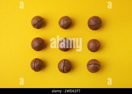 Tasty Macadamia nuts on yellow background, flat lay Stock Photo