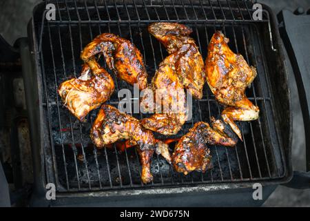 Barbeque pit chicken leg and thigh covered in BBQ sauce and spices and homemade spicy sauce flavourful and tasty Stock Photo