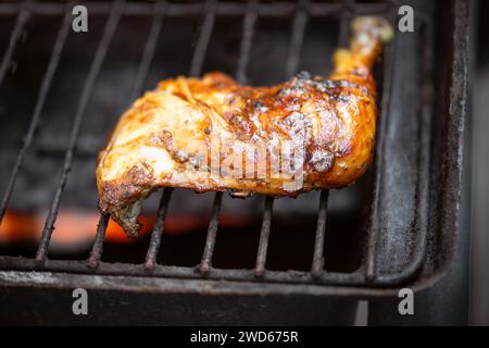 Barbeque pit chicken leg and thigh covered in BBQ sauce and spices and homemade spicy sauce flavourful Caribbean taste Stock Photo