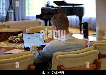 Young man working on laptop from home Stock Photo