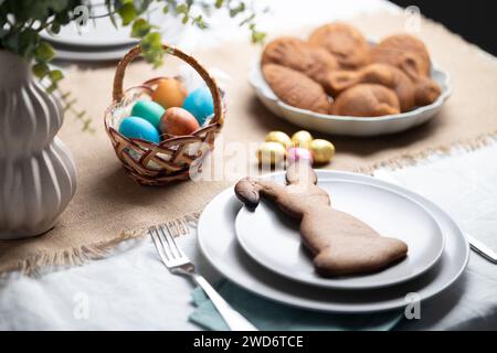 Gingerbread cookie shaped as Easter bunny on plate at decorated table Stock Photo