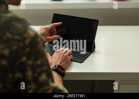 Caucasian soldier in army uniform in front of computer feeling happy and excited. American soldier receiving good news. Stock Photo