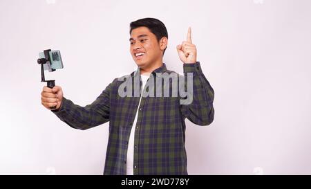 Asian man wearing a shirt make video blogging against white background Stock Photo