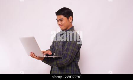 Asian student typing on a laptop against white background Stock Photo