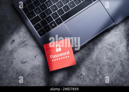 Red adhesive note on laptop with password written on it to protect information on digital devices. Cybersecurity and privacy protect data. Pin code. Stock Photo