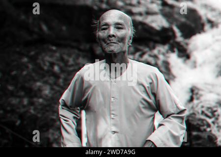 Portrait of an elderly Vietnamese octogenarian in the Park. Authentic Asian grandfather long-liver. Black and white photo with 3D glitch effect Stock Photo
