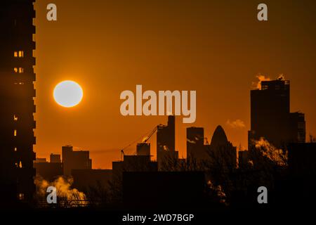 London, UK. 19th Jan, 2024. Crisp and freezing Winter Weather leads to an orange sky as the sun rises over the City of London. As steam rises from heating units. Credit: Guy Bell/Alamy Live News Stock Photo