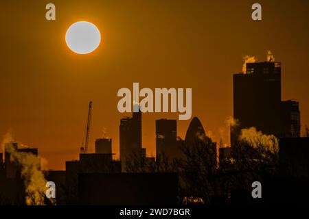 London, UK. 19th Jan, 2024. Crisp and freezing Winter Weather leads to an orange sky as the sun rises over the City of London. As steam rises from heating units. Credit: Guy Bell/Alamy Live News Stock Photo