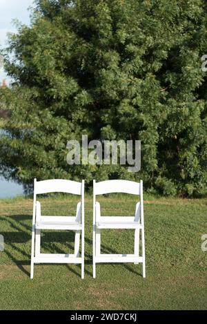 The two chairs placed on a green lawn set up for an outdoor wedding ceremony Stock Photo