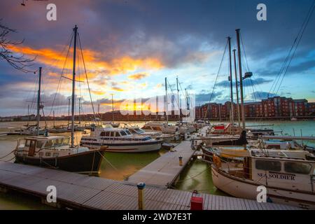 Preston, Lancashire.  UK Weather. 19 Jan 2024 Uk Weather. Sunrise over ice-covered Marina in Preston. The enclosed dockland frozen waters still hold an eerie blue green toxic algae which reflects the rising sun as a warm front takes over, bringing further weather warnings of strong winds and heavy rain.  Credit; MediaWorldImages/AlamyLiveNews Stock Photo