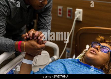 Multiracial couple breathes through contraction while holding hands Stock Photo