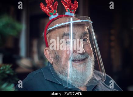 elderly man with protective visor and reindeer ears Stock Photo