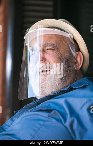 elderly man smiling under a protective visor Stock Photo