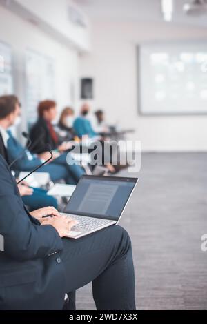 closeup of man using a laptop taking notes during a seminar presentation event Stock Photo