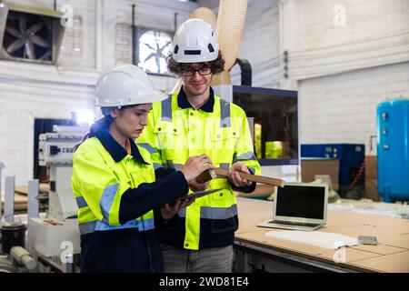 engineer team staff worker working in wooden furniture factory control operate wood cutter machine Stock Photo