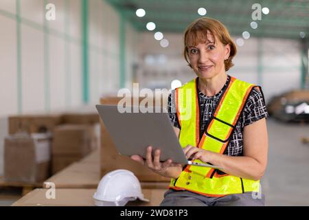 portrait senior engineer supervisor female factory indoor warehouse manager with laptop computer Stock Photo