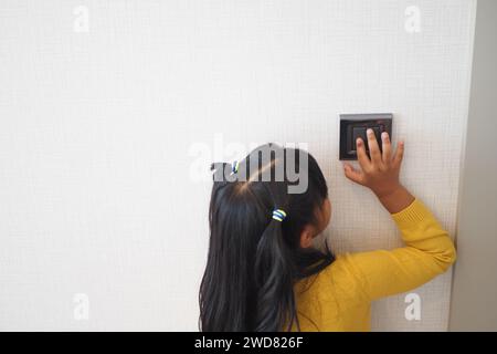 child finger turning on lighting switch with copyspace  Stock Photo