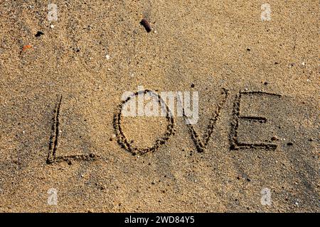 Love etched in the sands of serenity, a tranquil beach moment capturing romantic whispers on the shore. Stock Photo