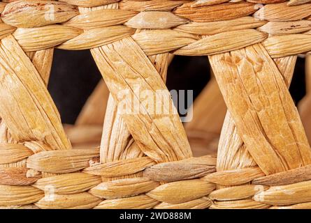 Close-up of a handwoven reed straw background texture, showing intricate weaves and patterns. The natural, earthy tones create a beautiful and rustic Stock Photo