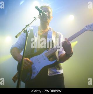 Man, singing and guitar or crowd at live concert performance for rock, music festival or audience. Male person, instrument and sound for entertainment Stock Photo