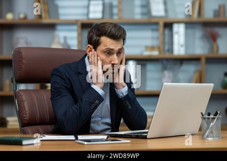 Mature businessman in deep concentration working on laptop in a home office. Professional looking financiary focused on screen. Stock Photo