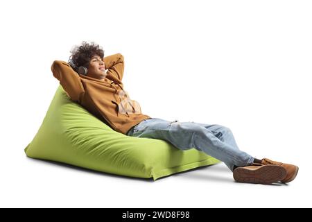 Guy with headphone resting on a green bean bag armchair isolated on white background Stock Photo