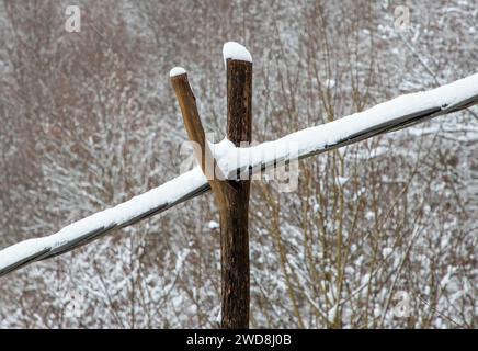 a close-up of an electrical cable hanging on an old, rustic wooden stand Stock Photo