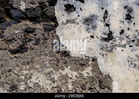 Detail of volcanic stone wall with worn out plaster coating, grunge background Stock Photo