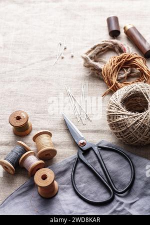 Scissors and spools of thread with a needles on a canvas Stock Photo