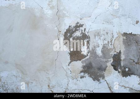 Detail of old cracked cement wall with white limewash plaster coating Stock Photo