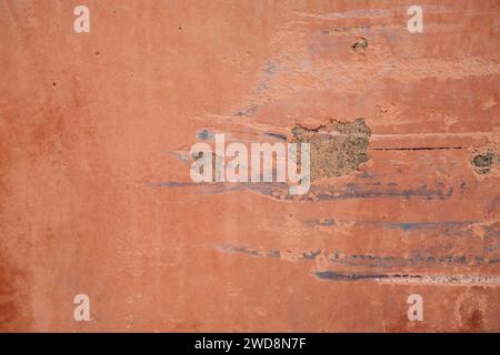 Old coral pink colored wall with crack, grunge background Stock Photo