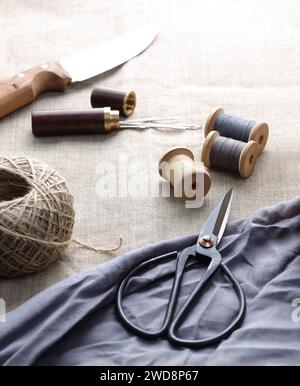 sewing threads with needles and scissors on a canvas.jpg Stock Photo