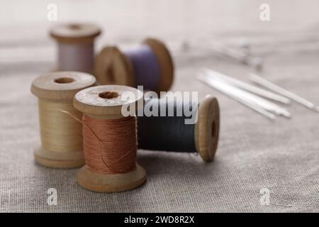 Spools of thread and a needles on a canvas Stock Photo