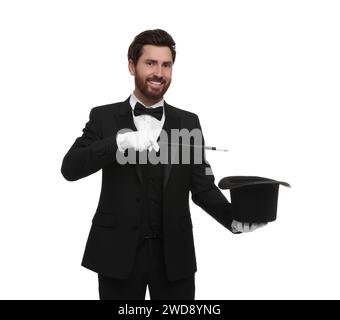 Happy magician showing magic trick with top hat on white background Stock Photo