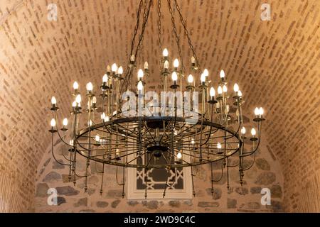 Old iron chandelier on the ceiling of a stone building Stock Photo