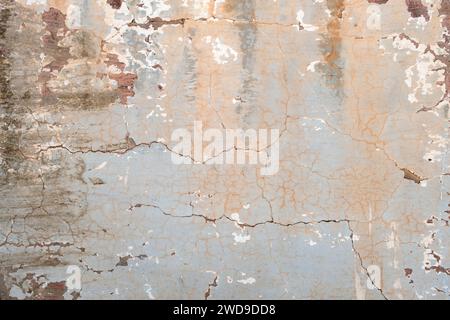 Old cracked wall with worn out blue paint, grunge background Stock Photo