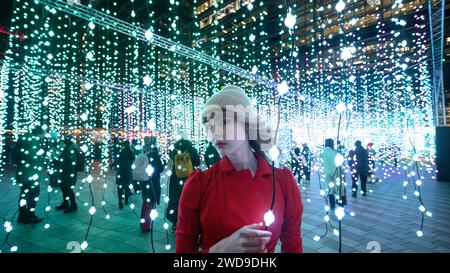 London, UK, 17th January 2024, Winter Lights at Canary Wharf opened for its 8th edition. Light installations are around the area for people to explore. It's free; it opened on the 17th till 27th January 2024. Julia a model from Norway was enjoying the lights on a very cold night, this art installation is called Submergence by Squidsoup., Andrew Lalchan Photography/Alamy Live News Stock Photo