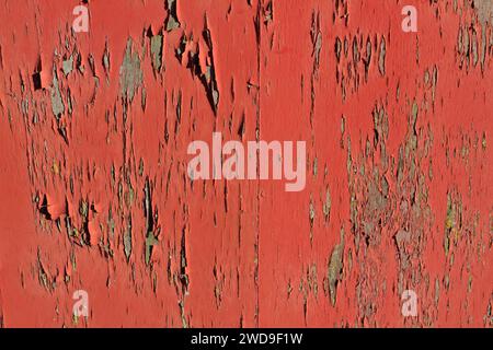 Abstract of peeling paint, a burnt orange colour with the original wood showing underneath. Stock Photo