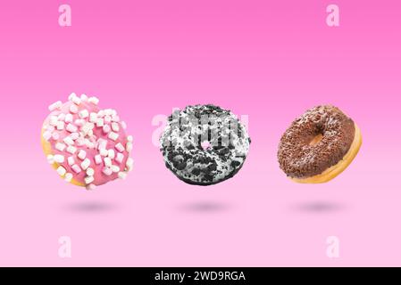 Delicious donut on color background. Mix of flying multicolored doughnuts Stock Photo