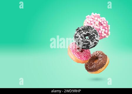 Delicious donut on color background. Mix of flying multicolored doughnuts Stock Photo