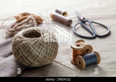 Needlework concept. Various sewing tools. Needles, scissors,  spools, threads of different colors. Sewing accessories and fabric Stock Photo