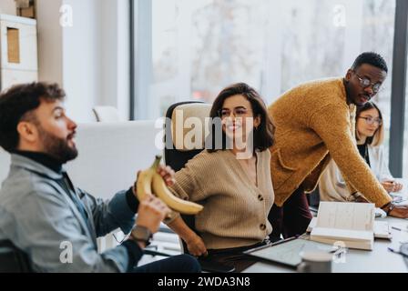 Multicultural team of employees collaborating and discussing reports in creative office Stock Photo