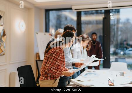 A diverse team of professionals collaborating in an office, focused on productivity and finding creative solutions for business growth. Stock Photo